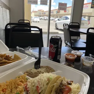 a plate of mexican food and a can of coke