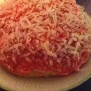 Pink frosted pastry with shredded sweetened coconut.