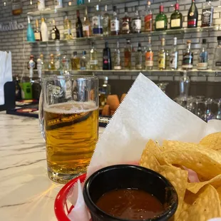 a basket of chips and a glass of beer