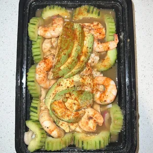 shrimp, avocado, and cucumbers in a sauce