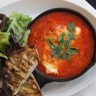 Baked eggs with spicy tomato sauce, peppers, basil and parmesan.