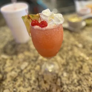 a drink with whipped cream and a cherry garnish