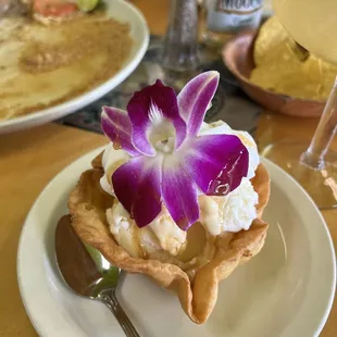 Dessert vanilla ice cream with an orchid.