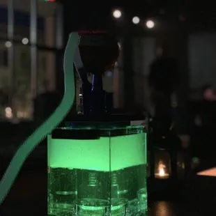 a bottle of liquid with a green glow