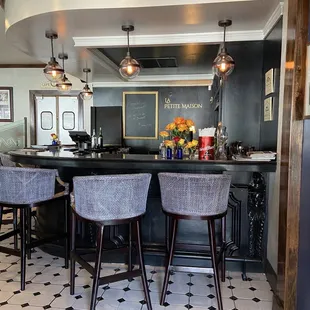 a bar with chairs and a chalkboard