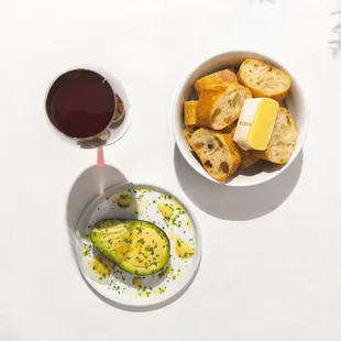 Avocado, bread and butter, a glass of red wine-- LA's finest lunch indulgence.