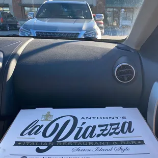 a pizza box in the passenger seat of a car