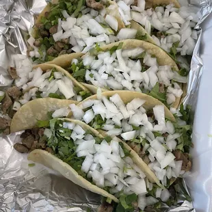 four tacos with onions and lettuce