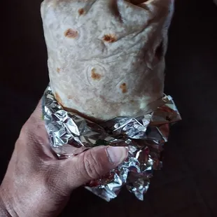 a hand holding a burrito
