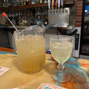 a pitcher of lemonade and a glass of lemonade