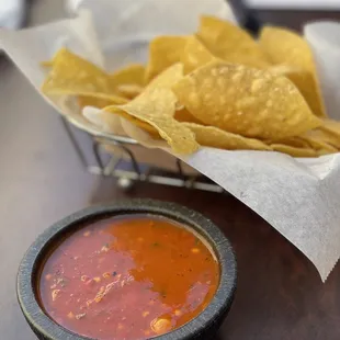 a basket of tortillas and a bowl of salsa