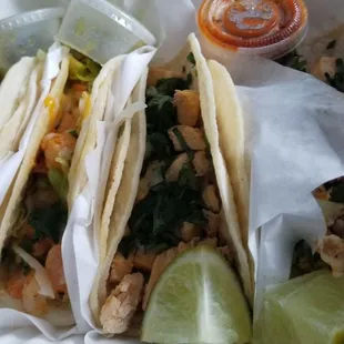 2 shrimp tacos on the left. 2 chicken tacos on the right.