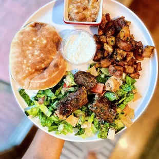 Warm bread, garlic drip, toum, spiced potatoes and fattoush with Impossible meat