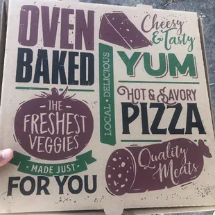 a hand holding a pizza box