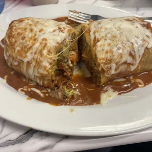 Super burrito with sauce and cheese added on top