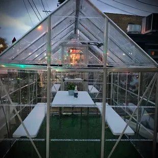 a table and chairs in a greenhouse