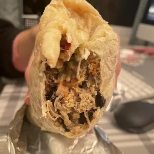 a person holding a burrito
