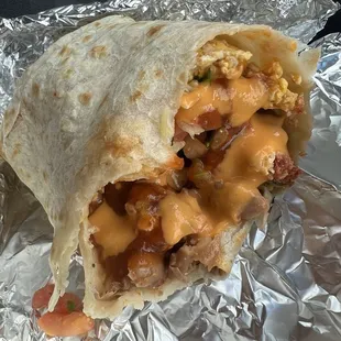 1/2 half eaten chorizo breakfast burrito ($9.99) with chipotle and orange salsa