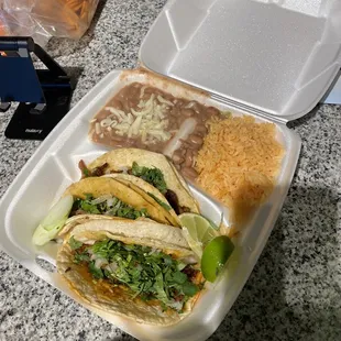 Taco combo: chorizo, al pastor, and asada traditional style with rice and beans