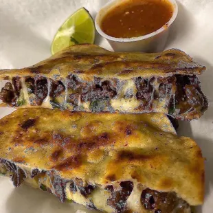 two quesadillas with a side of salsa