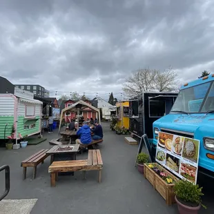 a man sitting at a table in front of a food truck
