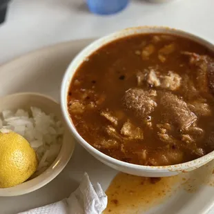 Small menudo with onions, lemon and corn tortillas.,