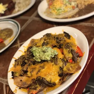 Bean and cheese nachos with beef fajitas and guacamole