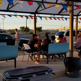a group of people sitting under a awning