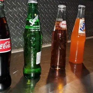 three bottles of soda on a counter