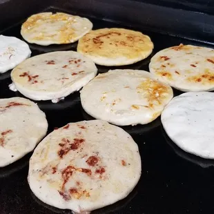 a grid of flatbreads cooking on a grill