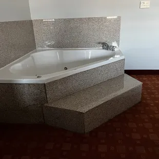 Jacuzzi in room with about 5ft of damp smelly carpet around it.