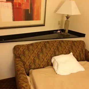 Weird triangular built in behind sofa that makes bed stick out too far in room.