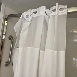 Shower used to be one with a glass door - now, glass door is just removed and then they put a normal shower curtain on the metal