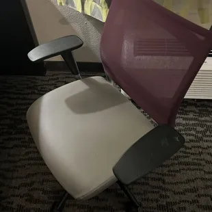 Worn out desk chair with white substance on the armrest