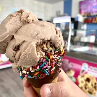 an ice cream cone with chocolate and sprinkles