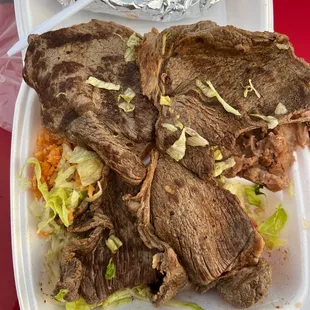 a beef sandwich and coleslaw in a styrofoam container