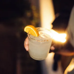 a person holding a glass of lemonade