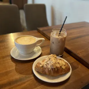 a cup of coffee and a croissant on a table