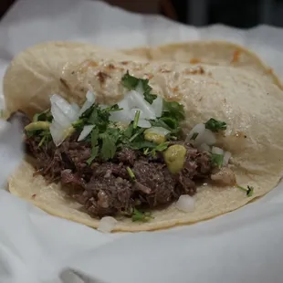 a taco with meat and onions