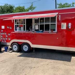 a red food truck parked in a parking lot