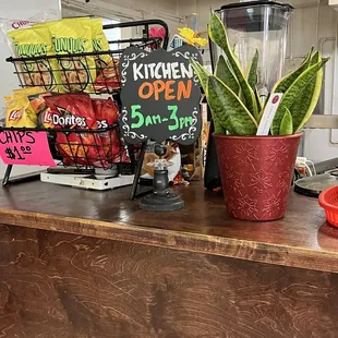 a counter with a blender and a sign