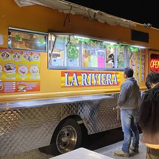 two people ordering food from a food truck