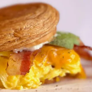 The &quot;BECA&quot; sandwich with crispy bacon, scrambled eggs, melted cheddar cheese, creamy avocado, all served on a soft and flaky New York Roll.