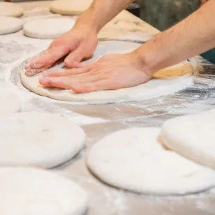 a person kning dough on a table