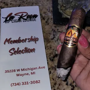 a hand holding a cigar