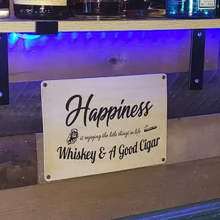 a sign that reads happiness whiskey and a good cigar