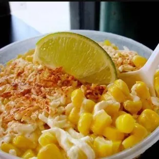 a bowl of macaroni and cheese with a lime wedge
