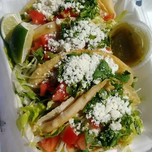 a taco with lettuce, tomatoes, and cheese