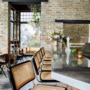 a long table with chairs in front of a brick wall