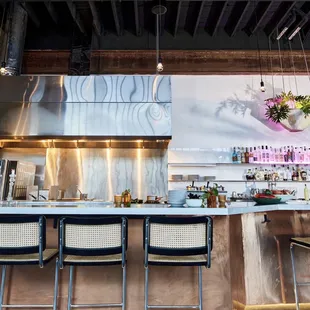 a kitchen with a bar and chairs